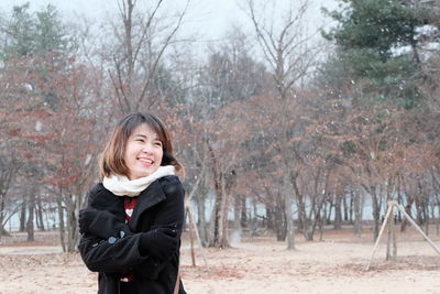 Portrait of smiling young woman standing in winter