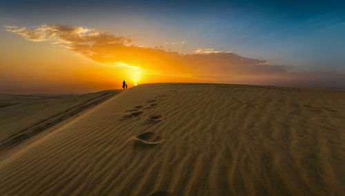 Scenic view of desert against sky during sunset