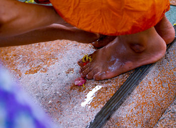 Cropped image of woman hand cleaning monk foot at temple