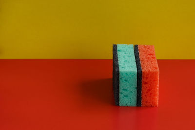 Close-up of colored pencils on table against wall