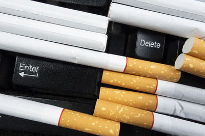 High angle view of cigarettes on computer keyboard