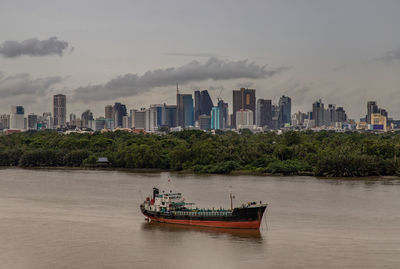 Boat in sea against buildings in city