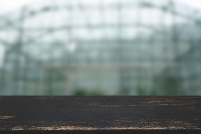 Close-up of railing on table against trees