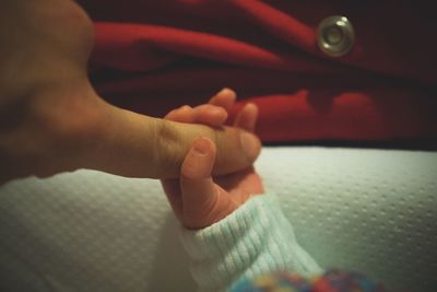 Close-up of mother holding baby hand