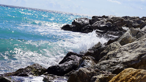 Close-up of splashing in sea against sky