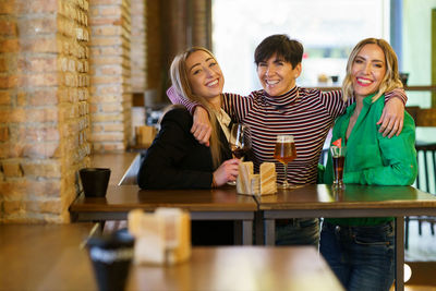 Portrait of smiling friends sitting at cafe