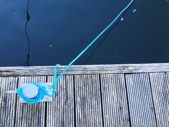 Directly above shot of rope tied to bollard on pier over lake