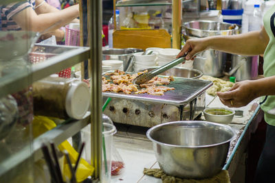 Hand of a woman frying meat for sale in orussey market in phnom penh