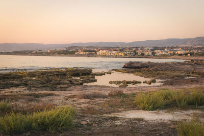 Scenic view of river against clear sky at sunset