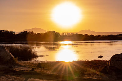 Scenic view of lake against sky during sunset