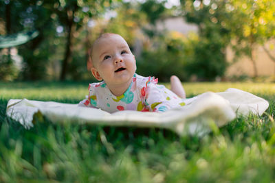 Portrait of cute boy lying on grass