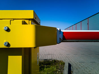 Low angle view of yellow building against clear blue sky