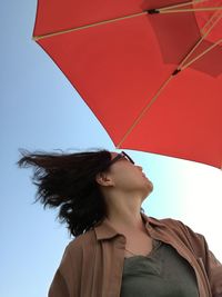 Woman with umbrella against clear sky