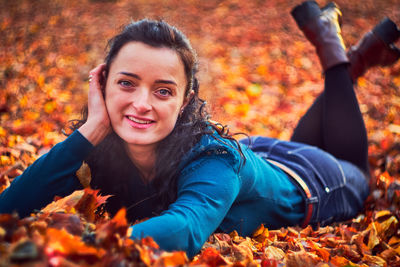 Portrait of smiling young woman with autumn leaves