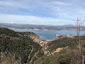 Aerial view of city by sea against sky