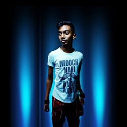 Portrait of young man standing against wall