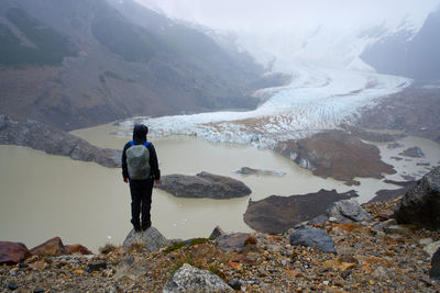 Man standing on rocks against mountains