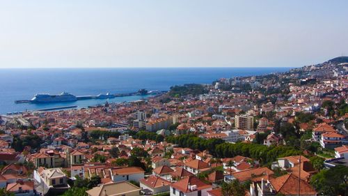 High angle view of city by sea against clear sky