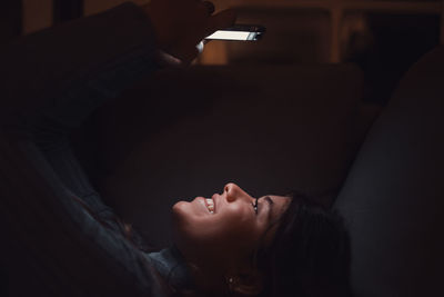 Portrait of woman lying on bed at home