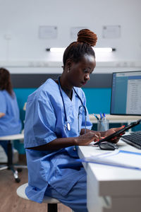 Nurse using digital tablet in clinic