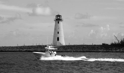 Lighthouse by sea against sky