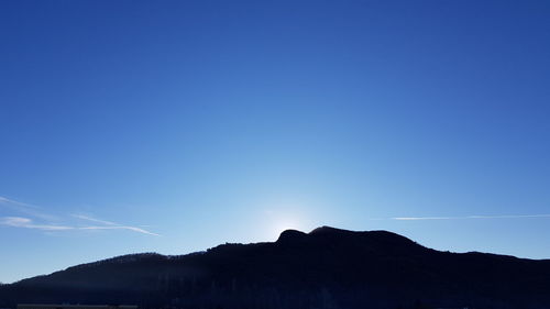 Silhouette mountains against clear blue sky