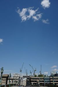 Low angle view of crane against clear blue sky