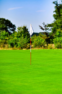 Golf flag on land against sky