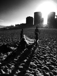 Silhouette of woman standing on beach at sunset