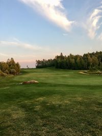 Scenic view of golf course against sky