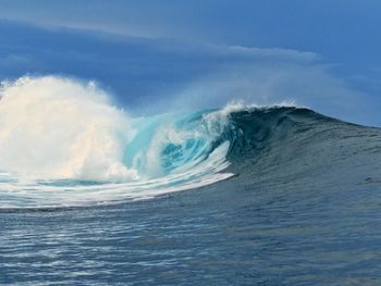 Scenic view of waves against blue sky