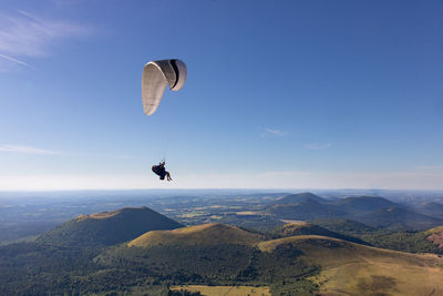 Low angle view of person paragliding against sky