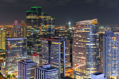 Illuminated buildings in city against sky at night