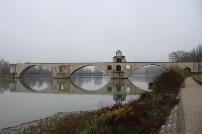 Arch bridge over river against sky