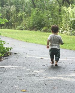 Rear view of toddler walking on road