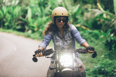 Female rider riding motor bike on road