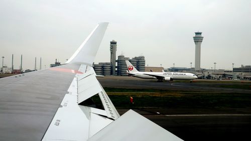 Airplane on airport runway against sky