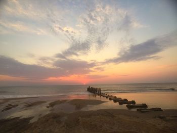 Scenic view of sea against dramatic sky during sunset