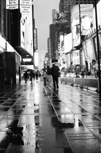 People walking on wet road in rainy season