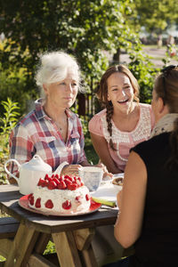 Four women enjoying cake and tea in garden