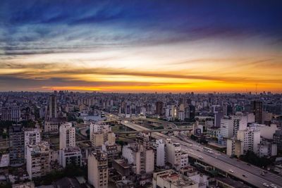 High angle view of modern buildings against sky during sunset