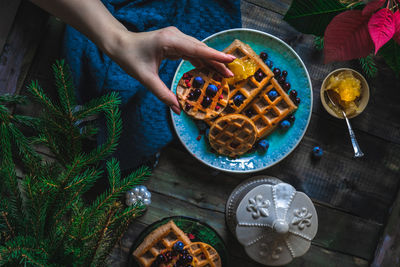 Cropped hand of woman holding food on table