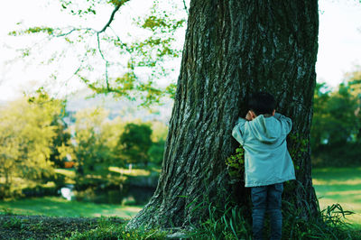 Full length of woman standing on tree trunk