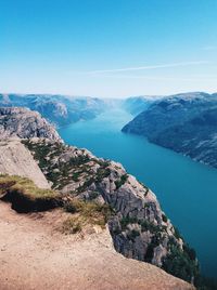 Scenic view of sea and rocky mountains against sky