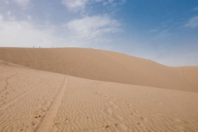 Sand dunes in desert against sky