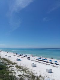 Scenic view of beach against blue sky