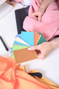 Cropped hands of woman showing color swatches on table