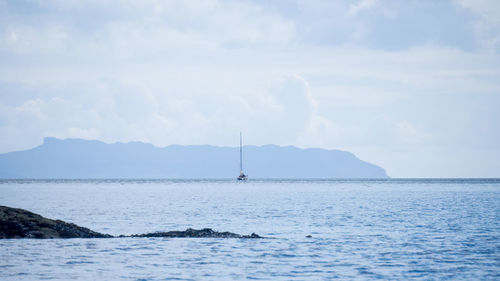 Sailboat sailing in sea against sky