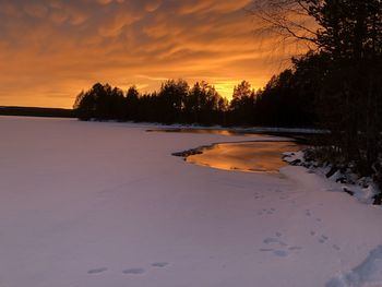 Scenic view of frozen lake against sky during sunset