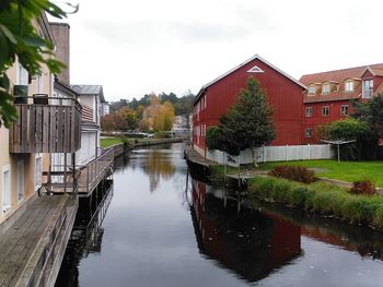 Canal amidst houses and buildings against sky